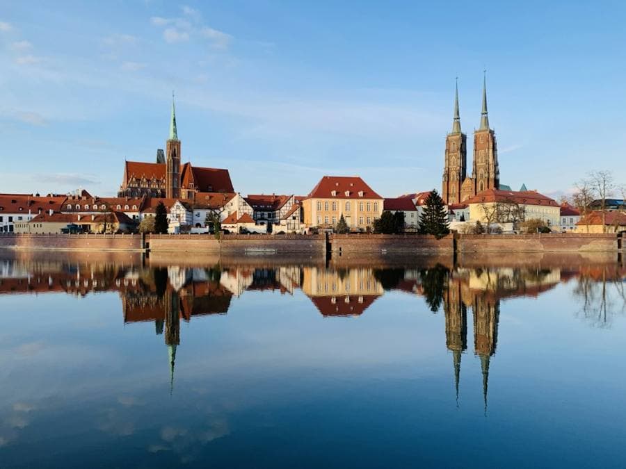 Wrocław's cathedral island mirrored in the river on a clear morning